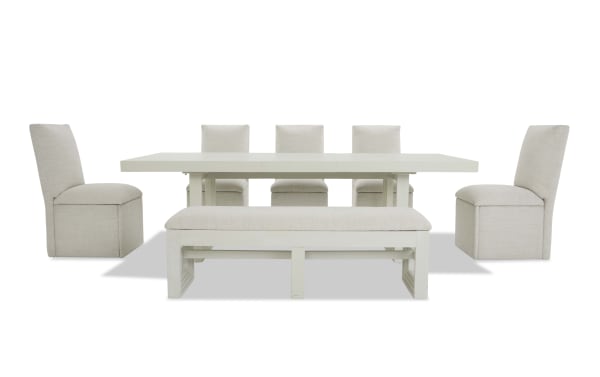 Modern dining set with a rectangular white wooden table, six beige upholstered chairs, and a matching cushioned bench, ideal for contemporary interiors.