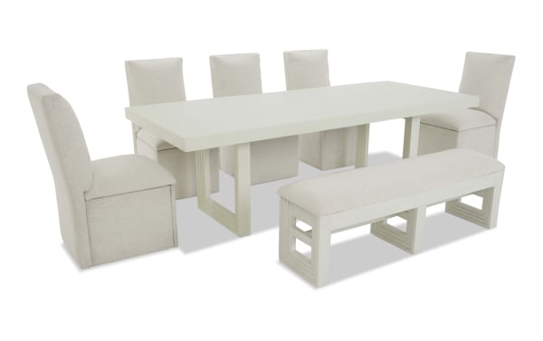 Modern white rectangular dining table set with six beige upholstered chairs and a matching cushioned bench, featuring wooden legs and a minimalist design.