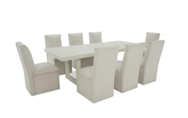 Modern dining set with a rectangular white table and eight beige upholstered high-back chairs, featuring a minimalist design and fabric texture.