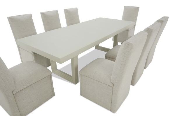 Rectangular beige upholstered dining table set with eight high-back chairs, featuring a light wood tabletop and sturdy geometric legs, ideal for modern dining rooms.
