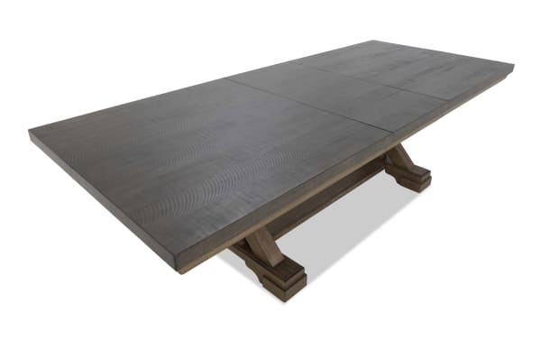 Rectangular dark wood dining table with a textured surface and sturdy double pedestal base, suitable for large dining spaces.