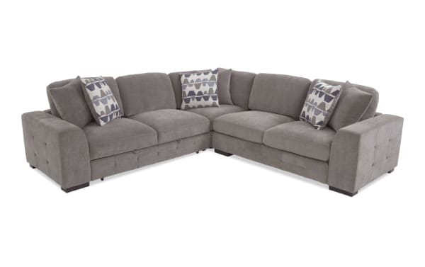 Gray fabric sectional sofa with tufted armrests, plush cushions, and geometric patterned throw pillows, ideal for modern living rooms.