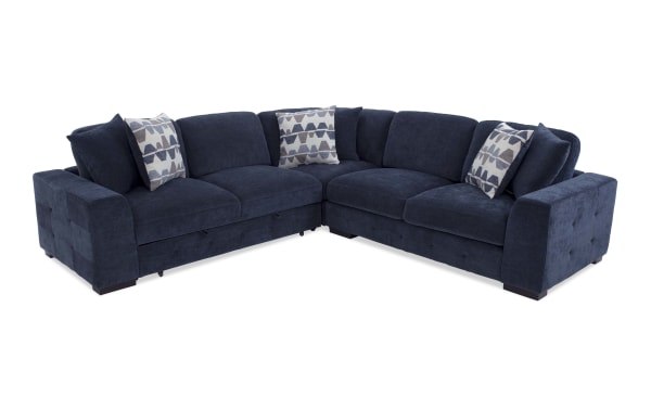 Dark blue fabric sectional sofa with tufted armrests, cushioned seats, and geometric patterned throw pillows, designed for modern living rooms.