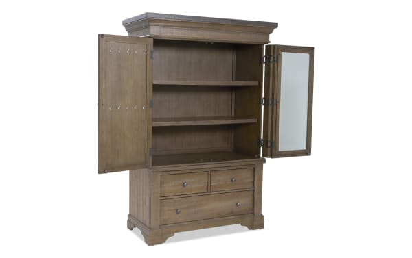 Wooden armoire with two open doors, featuring two shelves inside, a mirrored right door, and three lower drawers with metal knobs.