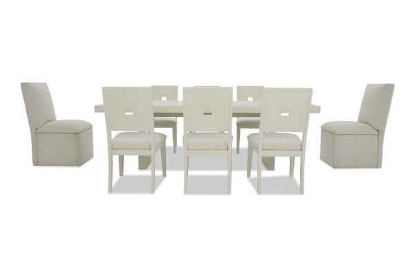 Modern dining table set with a rectangular white table and eight beige upholstered chairs featuring square cutout backrests and cushioned seats.