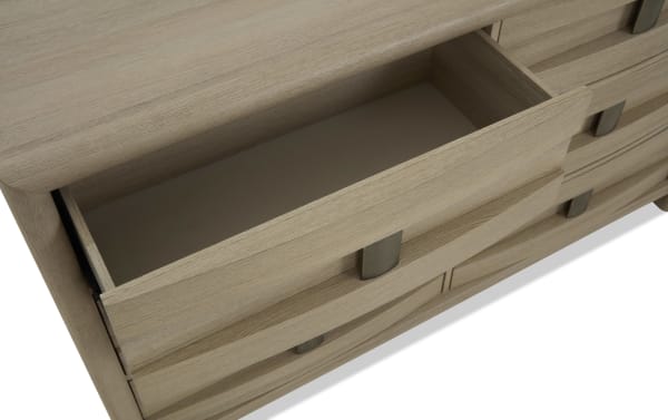 Light wood dresser drawer open, showing smooth interior and metal handle, highlighting storage functionality and natural wood grain finish.