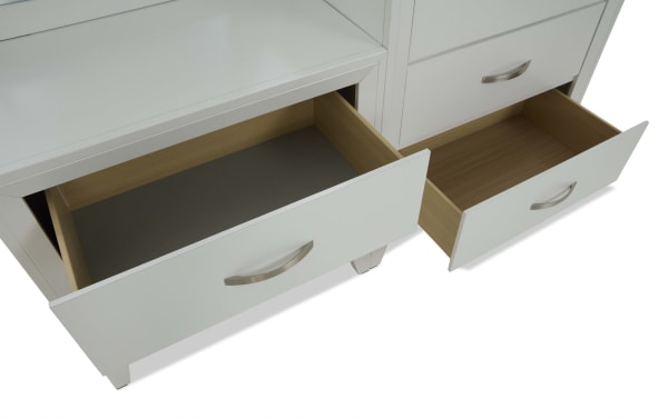 White wooden dresser drawers with silver curved handles, two drawers open showing light wood interiors, modern bedroom storage furniture.