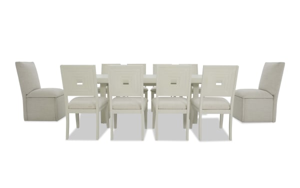 Modern dining set with a rectangular white table, six white wooden chairs with square cutout backs, and two beige upholstered end chairs.