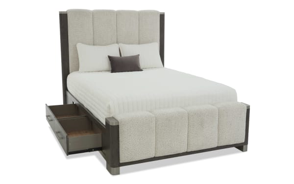 Modern upholstered bed with beige textured fabric, dark wood frame, and built-in side storage drawer, featuring a tall padded headboard and matching footboard.
