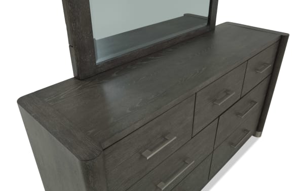 Dark wood dresser with a matching framed mirror, featuring nine drawers with modern metal handles, showcasing a sleek, contemporary bedroom storage solution.