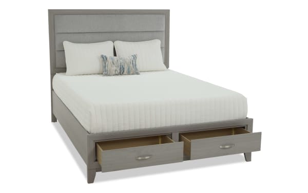 Queen-sized bed frame with light gray wood finish and upholstered headboard, featuring two spacious under-bed storage drawers with metal handles.