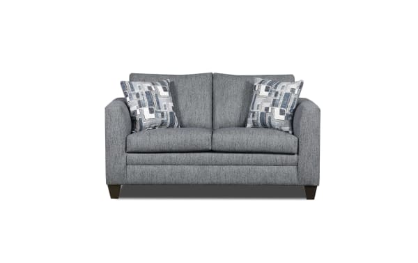 Gray fabric loveseat with modern square arms, two patterned blue and white throw pillows, and dark wooden legs, ideal for small living spaces.