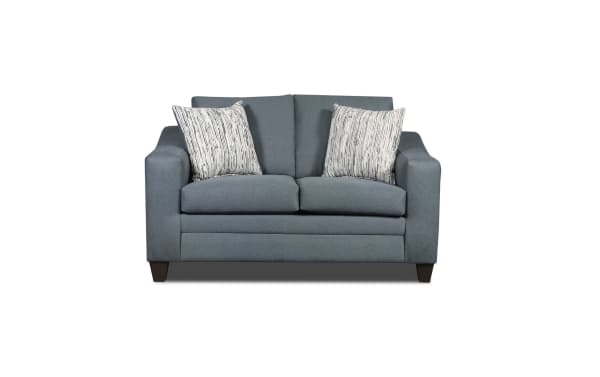 Blue fabric loveseat sofa with two patterned beige and blue throw pillows, featuring modern square arms and dark wooden legs.