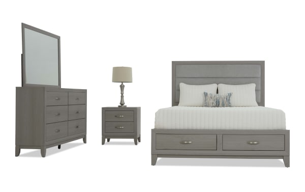 Gray wooden bedroom set including a king-size bed with upholstered headboard and storage drawers, matching nightstand with lamp, and six-drawer dresser with mirror.
