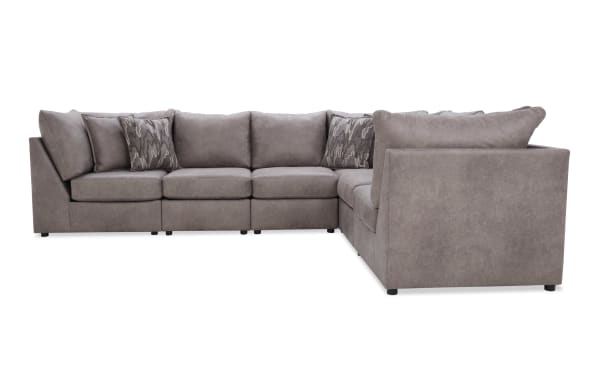 Large L-shaped sectional sofa in soft taupe microfiber fabric with plush cushions and patterned accent pillows, ideal for modern living rooms.
