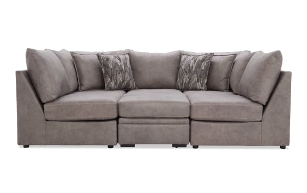 Modern gray fabric sectional sofa with plush cushions and patterned throw pillows, featuring a sleek, contemporary design for living room seating.