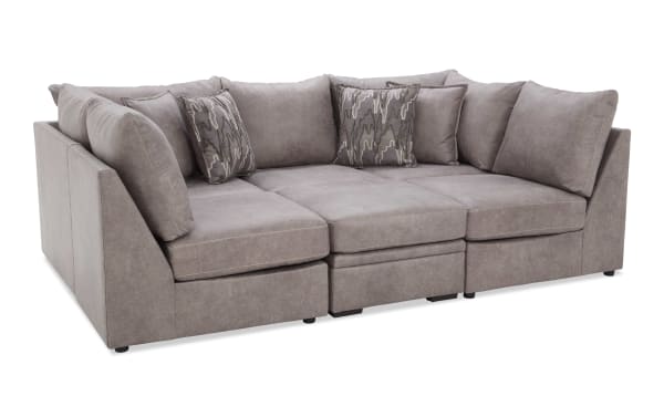 Modern sectional sofa in light gray microfiber fabric with plush cushions and patterned throw pillows, designed for comfortable living room seating.