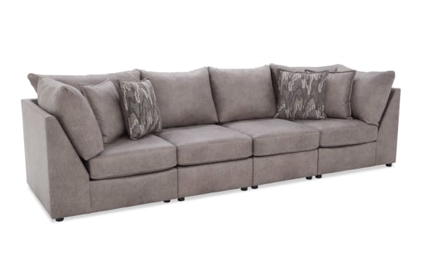 Modern gray fabric sectional sofa with plush cushions and patterned throw pillows, featuring a sleek, low-profile design ideal for contemporary living rooms.