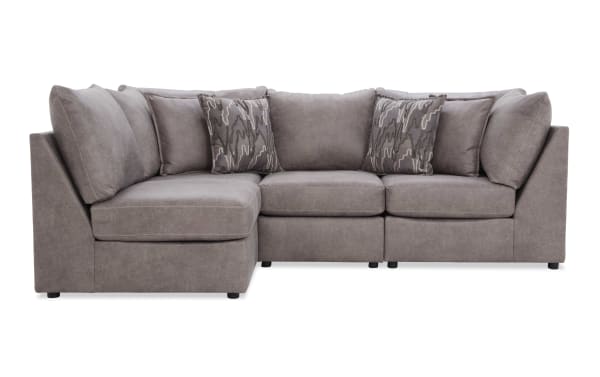 Modern L-shaped sectional sofa in soft gray microfiber fabric with plush cushions and patterned accent pillows, ideal for living room seating.