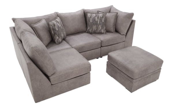 Modern sectional sofa set in gray microfiber fabric with plush cushions, two patterned throw pillows, and a matching ottoman for versatile living room seating.