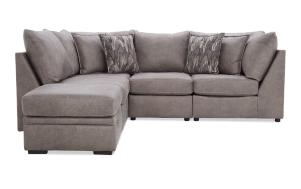 Gray sectional sofa with microfiber upholstery, L-shaped design, plush cushions, and patterned throw pillows, ideal for modern living rooms.