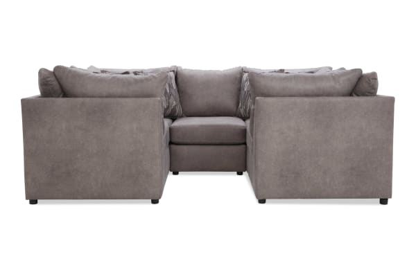 Modern U-shaped sectional sofa in taupe microfiber fabric with plush back cushions and patterned accent pillows, ideal for spacious living rooms.