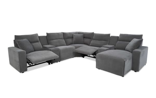 Large gray fabric sectional sofa with reclining seats and plush cushions, featuring a modern design and corner configuration for spacious living rooms.