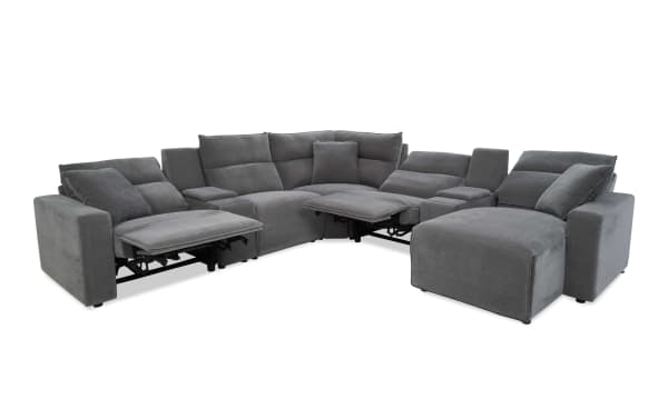 Large gray fabric sectional sofa with reclining seats on both ends, plush cushions, and a chaise lounge, designed for modern living rooms.