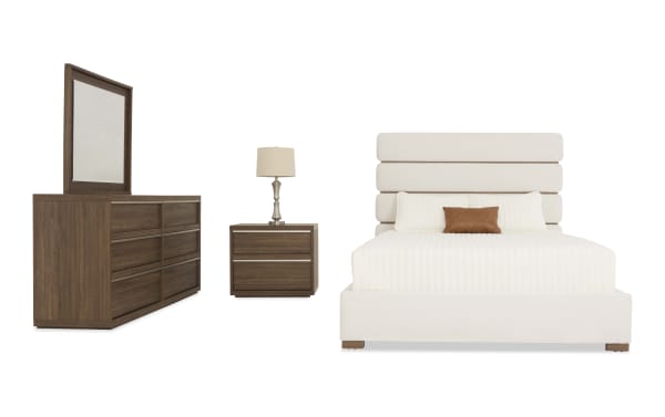 Modern bedroom set featuring a beige upholstered bed with a segmented headboard, a wooden nightstand with two drawers and a lamp, and a matching wooden dresser with six drawers and an attached mirror.