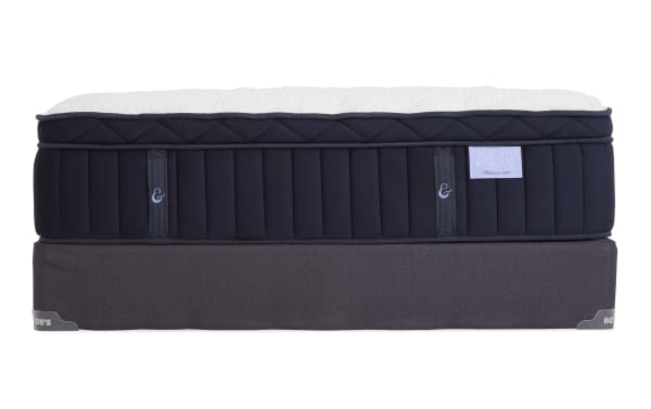 Mattress and foundation set with a navy blue quilted fabric mattress labeled "Crescent & Cloud Obsession Firm" featuring vertical stitching and handles, paired with a dark gray fabric foundation from Bob's.