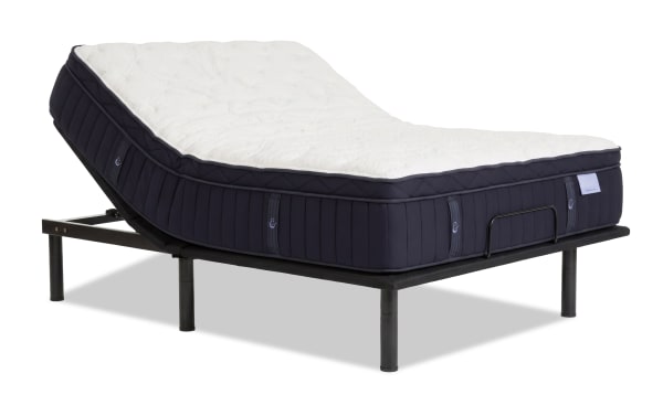 Adjustable bed frame with black metal legs and a dark navy blue mattress featuring a white quilted top, designed for customizable comfort and support.