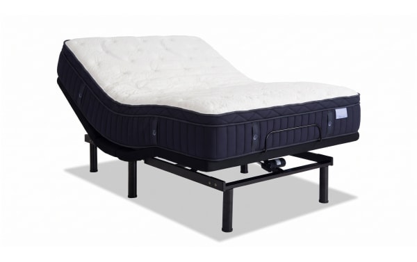 Adjustable electric bed with a black metal frame and a thick, tufted mattress featuring a white quilted top and dark navy sides, designed for customizable comfort and support.