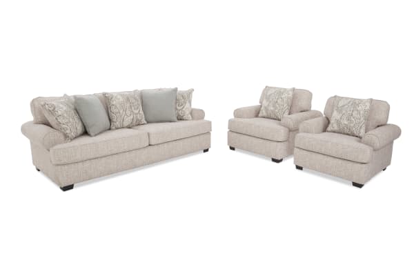 Beige fabric living room sofa set with rolled arms, including a three-seater couch and two matching armchairs, each with patterned and solid throw pillows.
