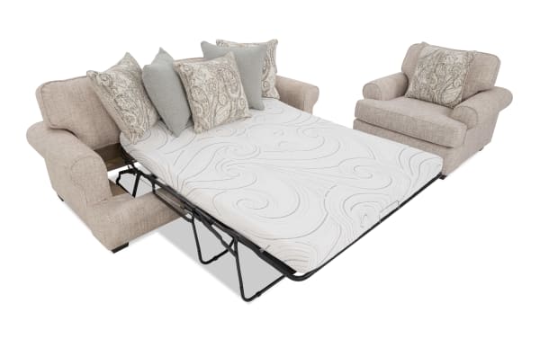 Beige fabric sectional sofa with rolled arms and patterned throw pillows, featuring a pull-out metal frame queen sleeper mattress with a white embossed cover.