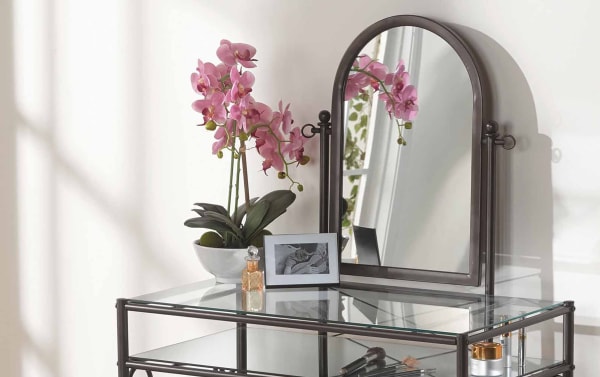 Levi Bronze Vanity Set with beige polyester fabric stool, curvy bronze steel frame, glass top and shelf, transitional style.