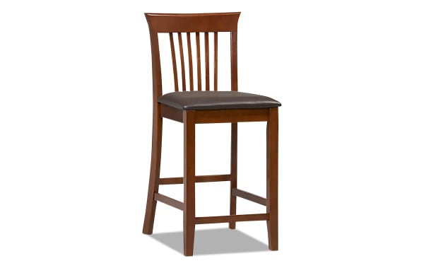 Craftsman Dark Cherry Slat Back Counter Height Stool with dark cherry rubberwood frame, transitional style, and dark brown polyurethane padded seat.