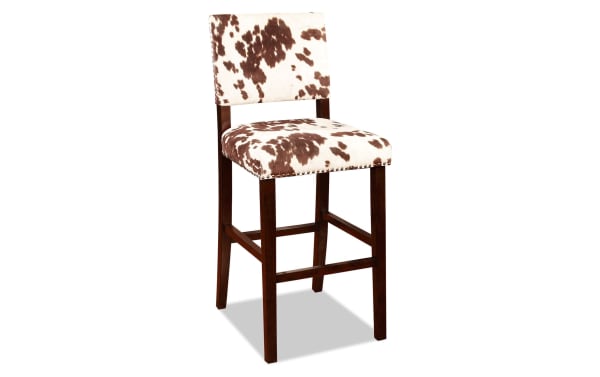 Corey Udder Madness Multi upholstered bar height stool with brown and white cow print polyester fabric, rubberwood legs in Manhattan stain, transitional style.