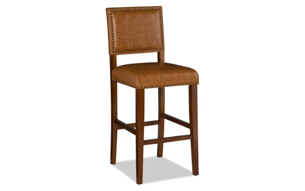 Marie Brown faux leather upholstered bar height stool in camel with nailhead trim, solid rubberwood frame, and contemporary style for kitchen or dining.