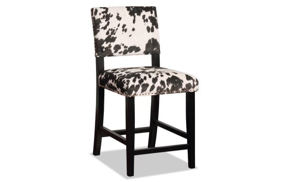 Corey Black & White Upholstered Counter Height Stool with cowprint polyester fabric, matte black rubberwood frame, silver nailhead trim, traditional style.