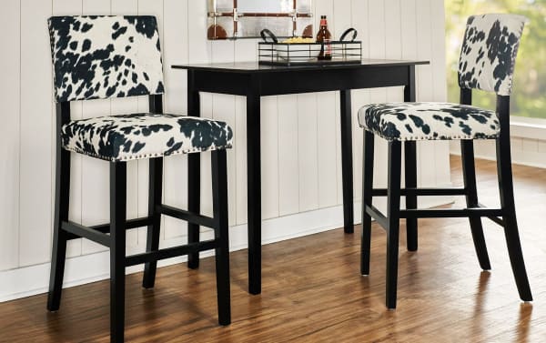 Corey Black & White Upholstered Bar Height Stool with cowprint polyester fabric, matte black rubberwood frame, silver nailhead trim, traditional style.