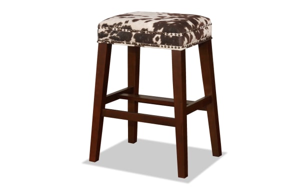 Kristen Cow Print Walnut Backless Upholstered Bar Height Stool with brown cowprint polyester fabric, walnut-finished rubberwood legs, and silver nailhead trim, traditional style.