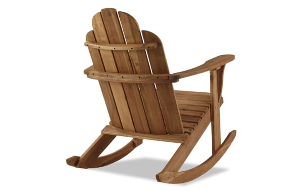 Traditional Joan Brown solid acacia wood outdoor Adirondack rocker chair with high back, curved armrests, and teak finish for porch or poolside.
