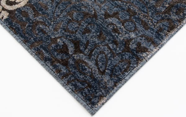 Corner close-up of the Hoboken 5' x 8' Gray Damask Rug showing intricate blue, gray, beige, and black medallion pattern in transitional style, made of durable polyester and polypropylene fabric.