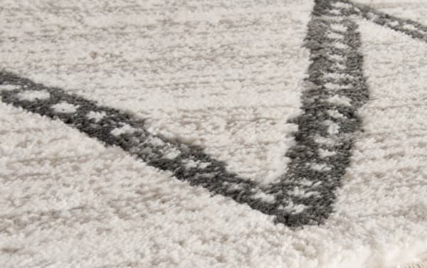 Contemporary Chloe 5' x 8' white geometric rug with gray and ivory polypropylene yarn, featuring soft texture and bold angular pattern.