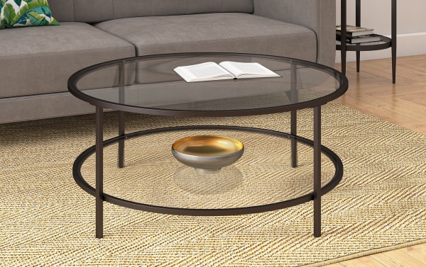 Contemporary Linda Blackened Bronze Round Coffee Table with tempered glass top and lower shelf, hand-finished steel frame, ideal for modern living rooms.