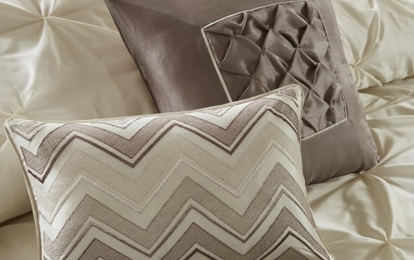 Contemporary Alan Queen Ivory Solid 24 Piece Comforter Set with beige polyester fabric, featuring tufted and chevron patterned decorative pillows for a cozy bedroom makeover.