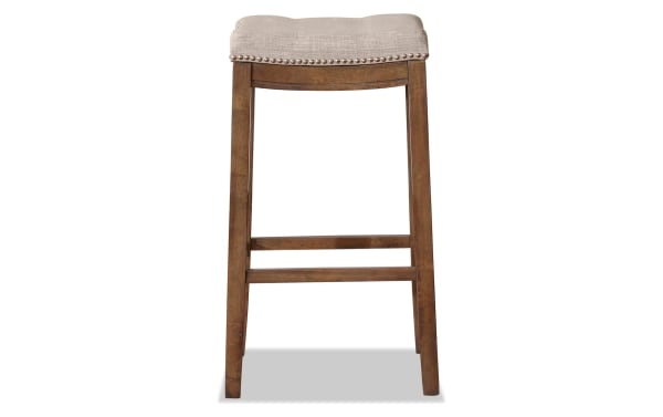 Ryann Gray Upholstered Backless Bar Height Stool in gray linen fabric with rubberwood frame, rustic finish, and silver nailhead trim, transitional style.