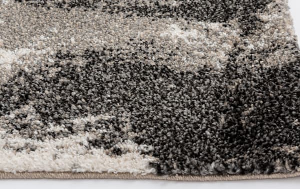 Close-up of Rave 5' x 7' Ivory Abstract Rug in cream, black, and beige polypropylene with a textured, transitional abstract pattern and tan tones.