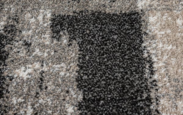 Transitional Rave 5' x 7' Ivory Abstract Rug in cream, black, and beige with a unique abstract pattern, made of durable polypropylene fibers.