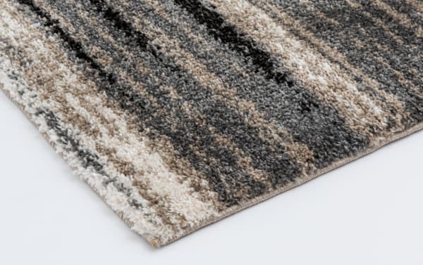 Transitional Bay 5' x 7' Gray Abstract Rug with gray, black, and taupe polypropylene fibers, featuring a modern striped pattern and durable stain-resistant weave.
